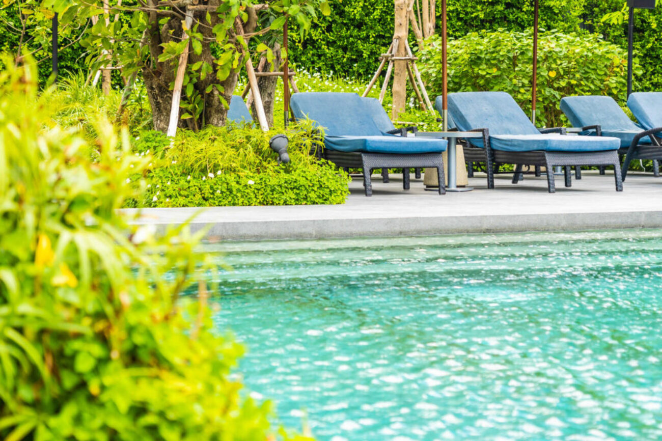 Beautiful outdoor swimming pool in hotel and resort with chair a