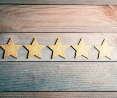 5 Golden Stars Lying Down On Wooden Board - View From Above - Top Quality Concept