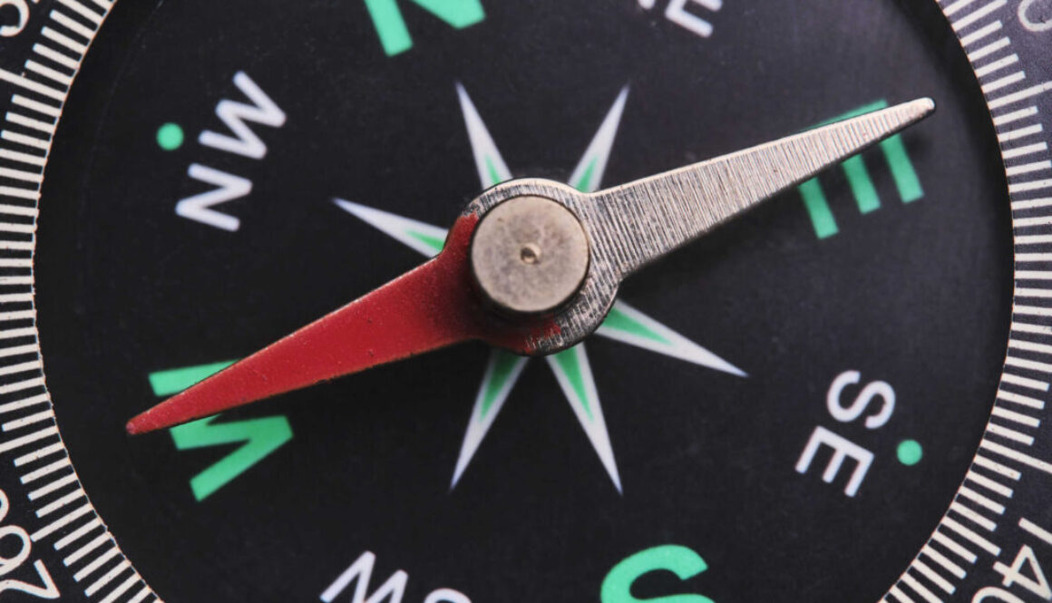 Dial compass in closeup, arrow indicates direction west.