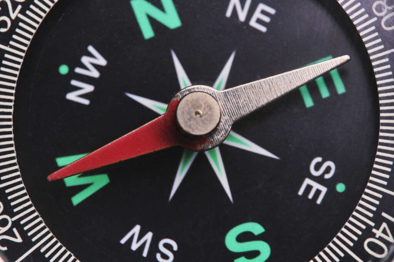 Dial compass in closeup, arrow indicates direction west.