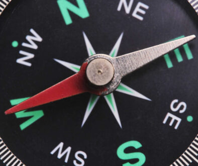 Dial compass in closeup, arrow indicates direction west.