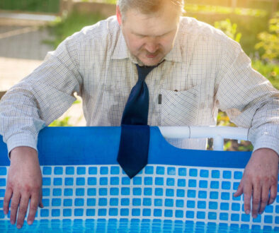 A handsome man in a business suit is suffering from the heat by
