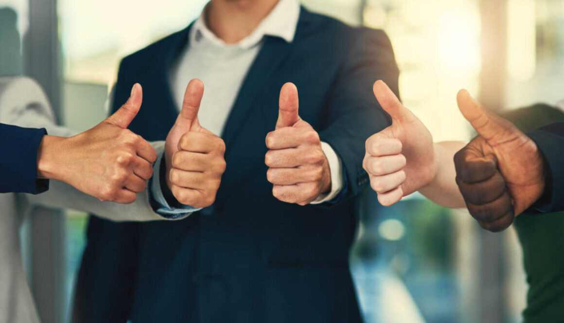 Youre our most valued employee. Cropped shot of a group of businesspeople giving thumbs up in a modern office.