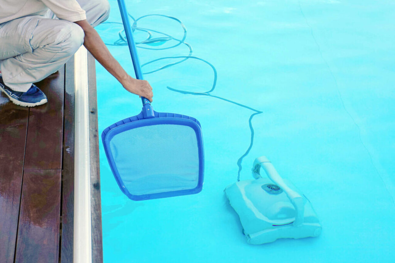 Hotel african staff worker cleaning the pool