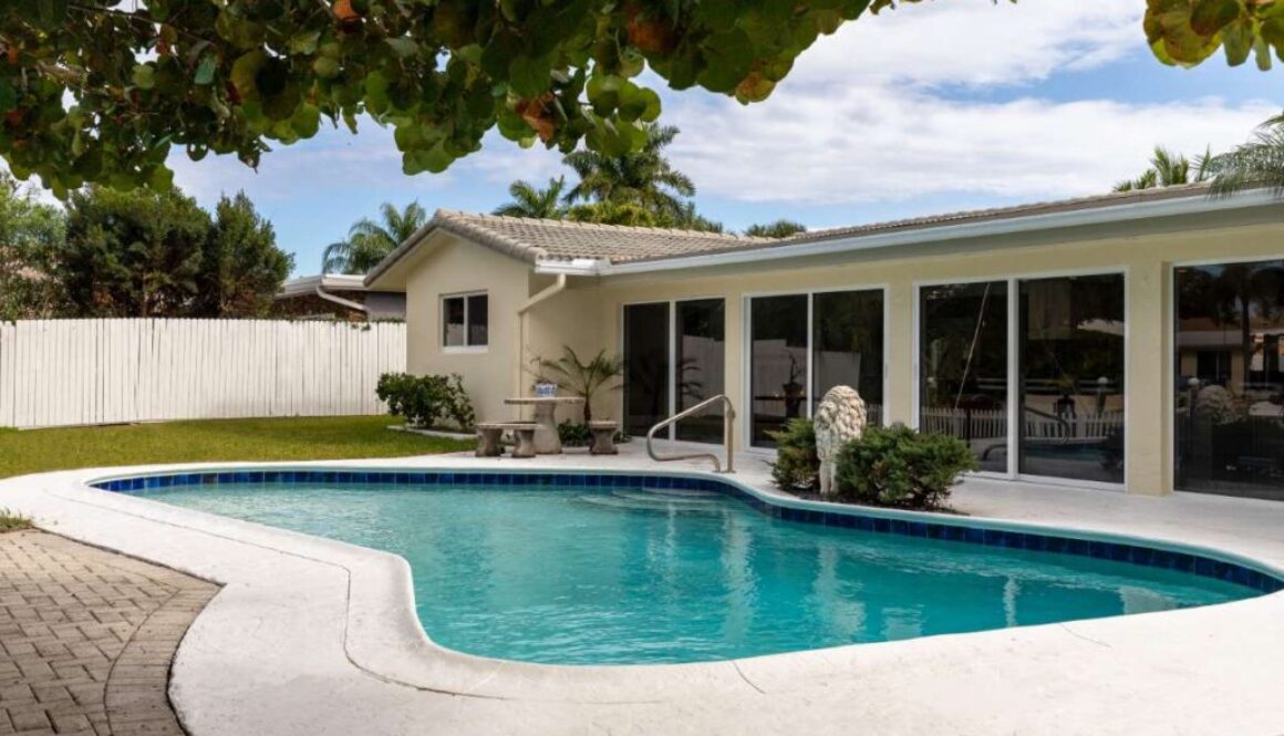 backyard-modern-house-with-swimming-pool-artificial-grass-stone-path-trees-chairs-umbre(1)_0x800