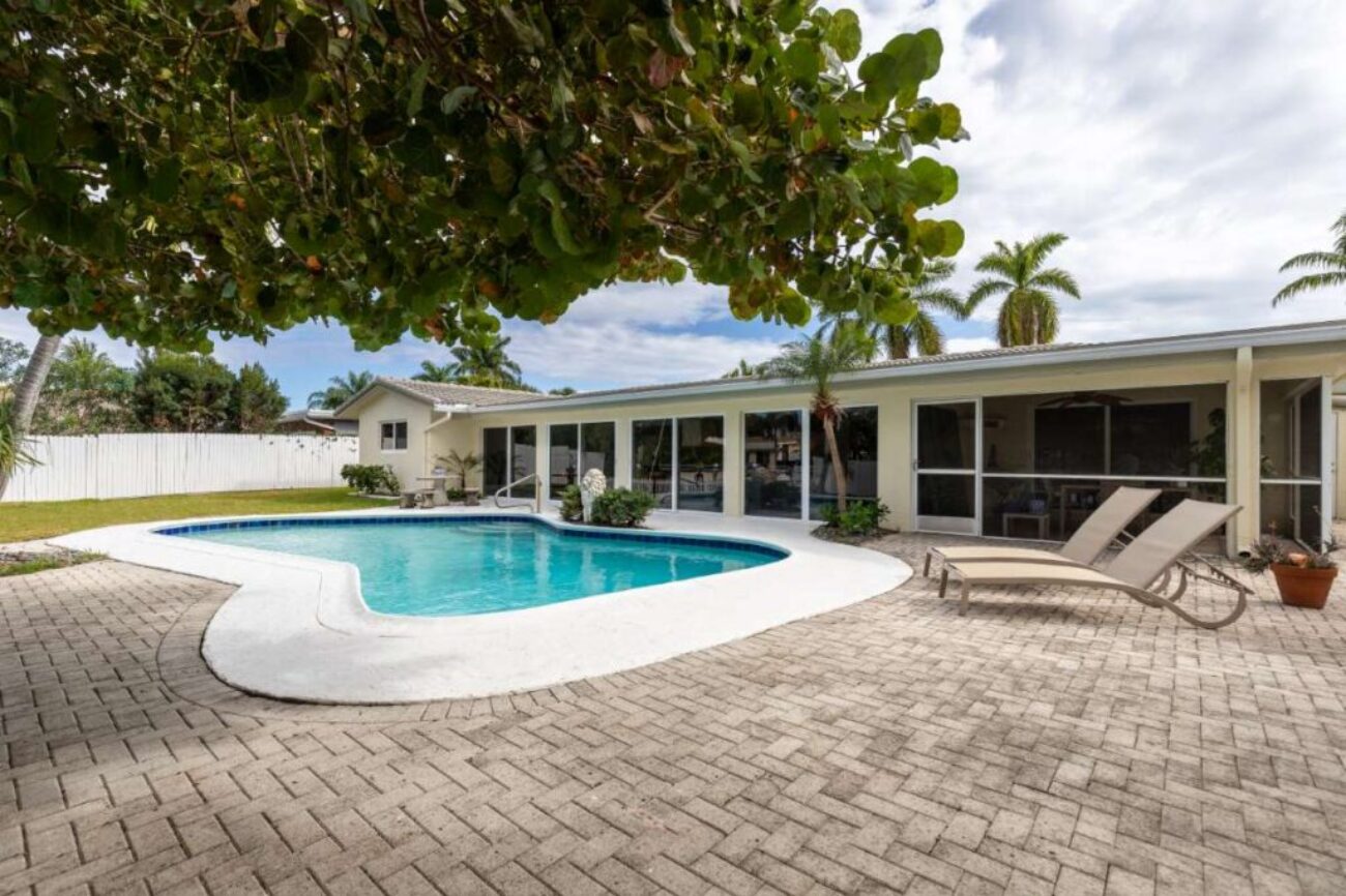 backyard-modern-house-with-swimming-pool-artificial-grass-stone-path-trees-chairs-umbre_0x800
