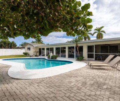 backyard-modern-house-with-swimming-pool-artificial-grass-stone-path-trees-chairs-umbre_0x800