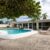 backyard-modern-house-with-swimming-pool-artificial-grass-stone-path-trees-chairs-umbre_0x800