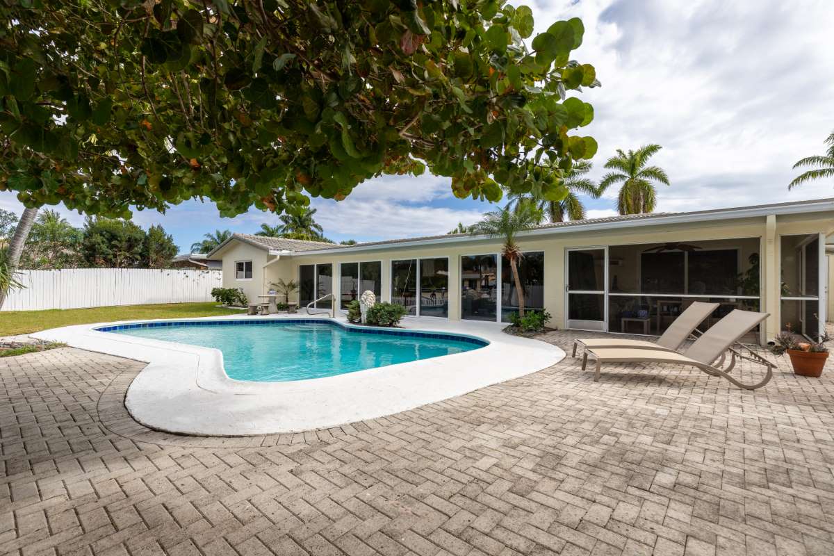 backyard-modern-house-with-swimming-pool-artificial-grass-stone-path-trees-chairs-umbre_0x800