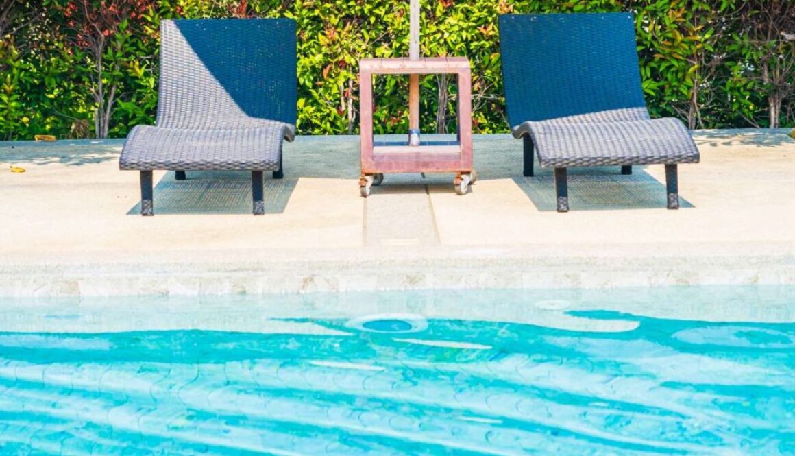 Umbrella and chair around outdoor swimming pool in hotel resort