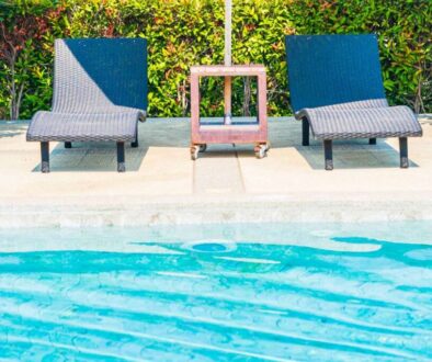 Umbrella and chair around outdoor swimming pool in hotel resort