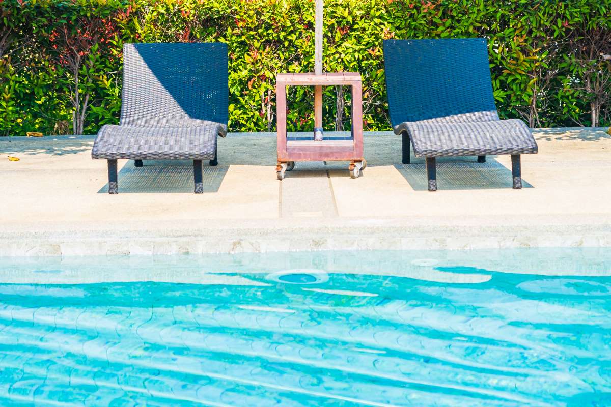 Umbrella and chair around outdoor swimming pool in hotel resort