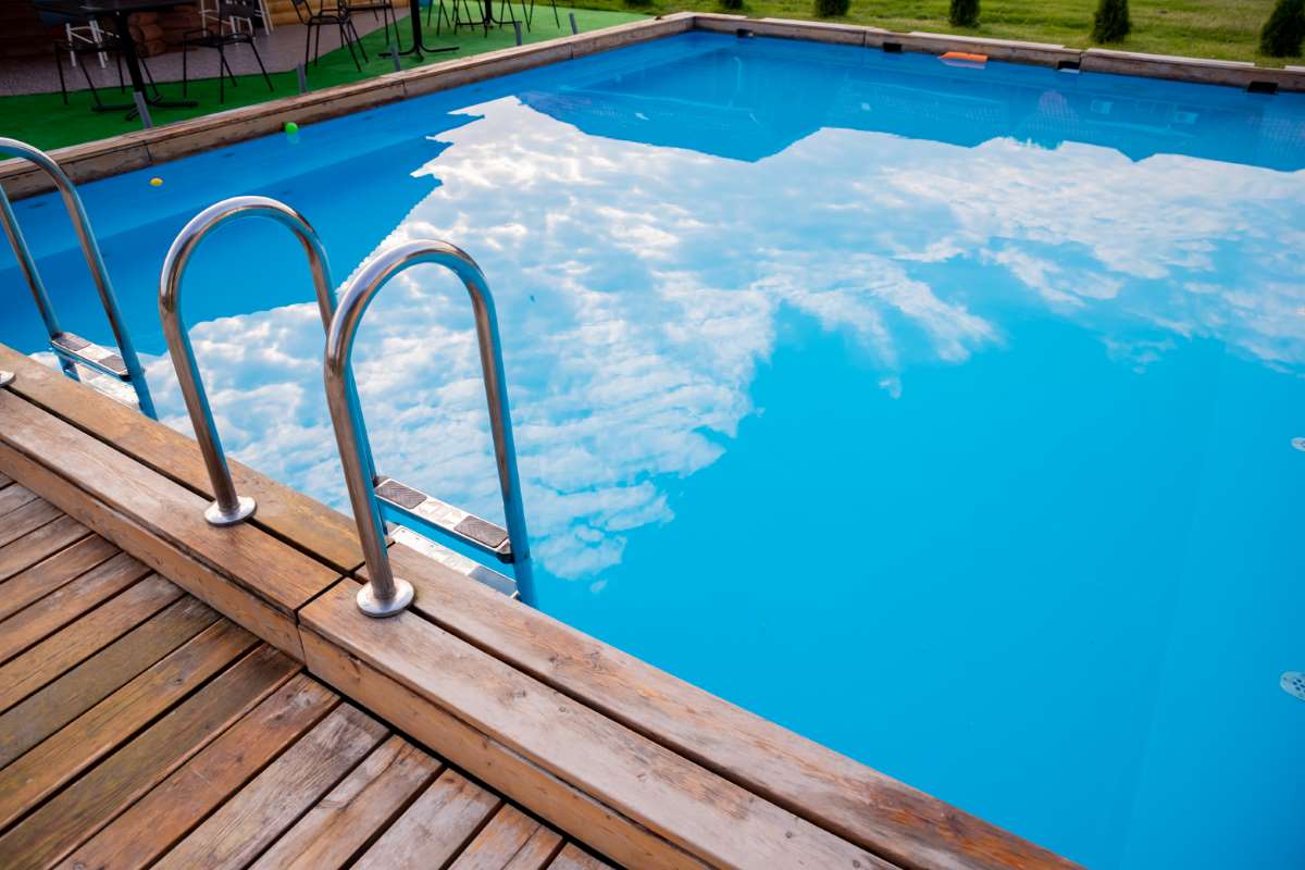 Ladder stainless handrails for descent into swimming pool.