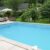 Outdoor swimming pool with blue water near the garden