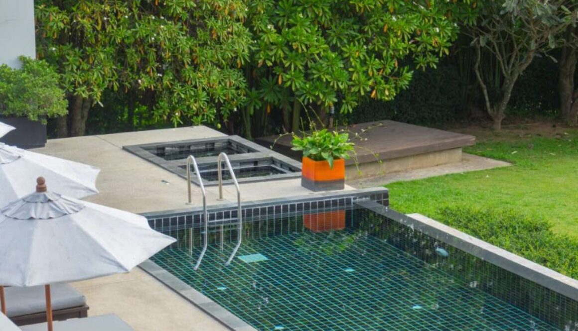 Swimming pool with metal stair with green nature backgroun