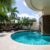 backyard-modern-house-with-swimming-pool-artificial-grass-stone-path-trees-chairs_0x800