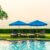 beach-chair-pool-bed-with-umbrella-around-swimming-pool-with-sunset-sea_0x800