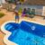 man-with-straw-hat-dressed-swimming-trunks-cleaning-his-pool-with-pool-cleaner-stick-from-leaf_0x800