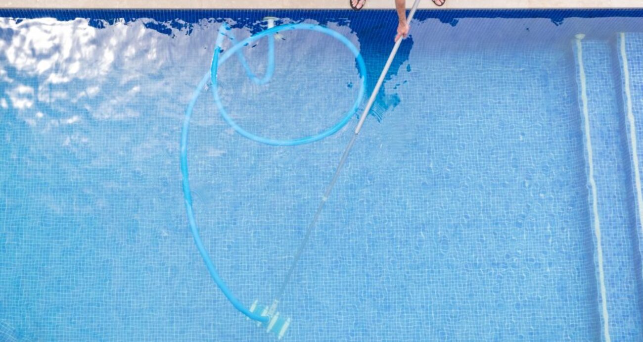 top view of man cleaning a swimming pool