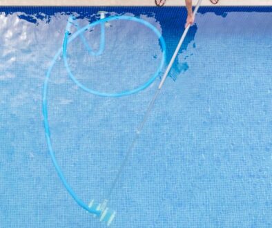 top view of man cleaning a swimming pool