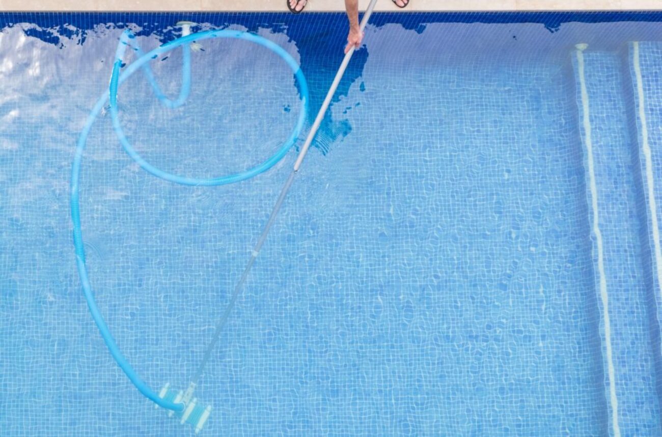 top view of man cleaning a swimming pool