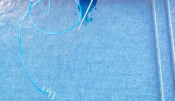 top view of man cleaning a swimming pool