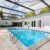 backyard-modern-house-with-swimming-pool-artificial-grass-stone-path-trees-chairs_0x800