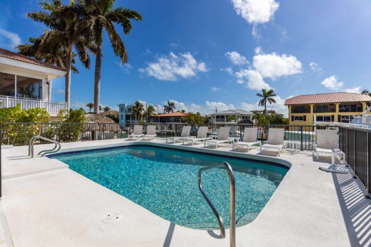 modern-building-with-swimming-pool-trees-chairs-landscape-with-blue-sky-scenic-enviroment_0x800