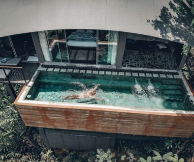aerial-view-fit-male-swimming-clear-pool-that-is-balcony-hotel-palms-around-arched-grey-roof-recreation-concept_0x800