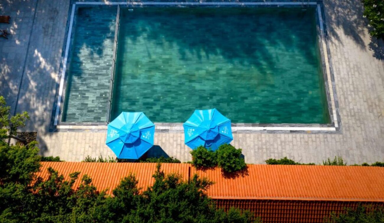 blue-umbrellas-by-poolside-photo_0x800