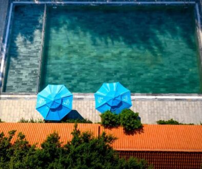 blue-umbrellas-by-poolside-photo_0x800