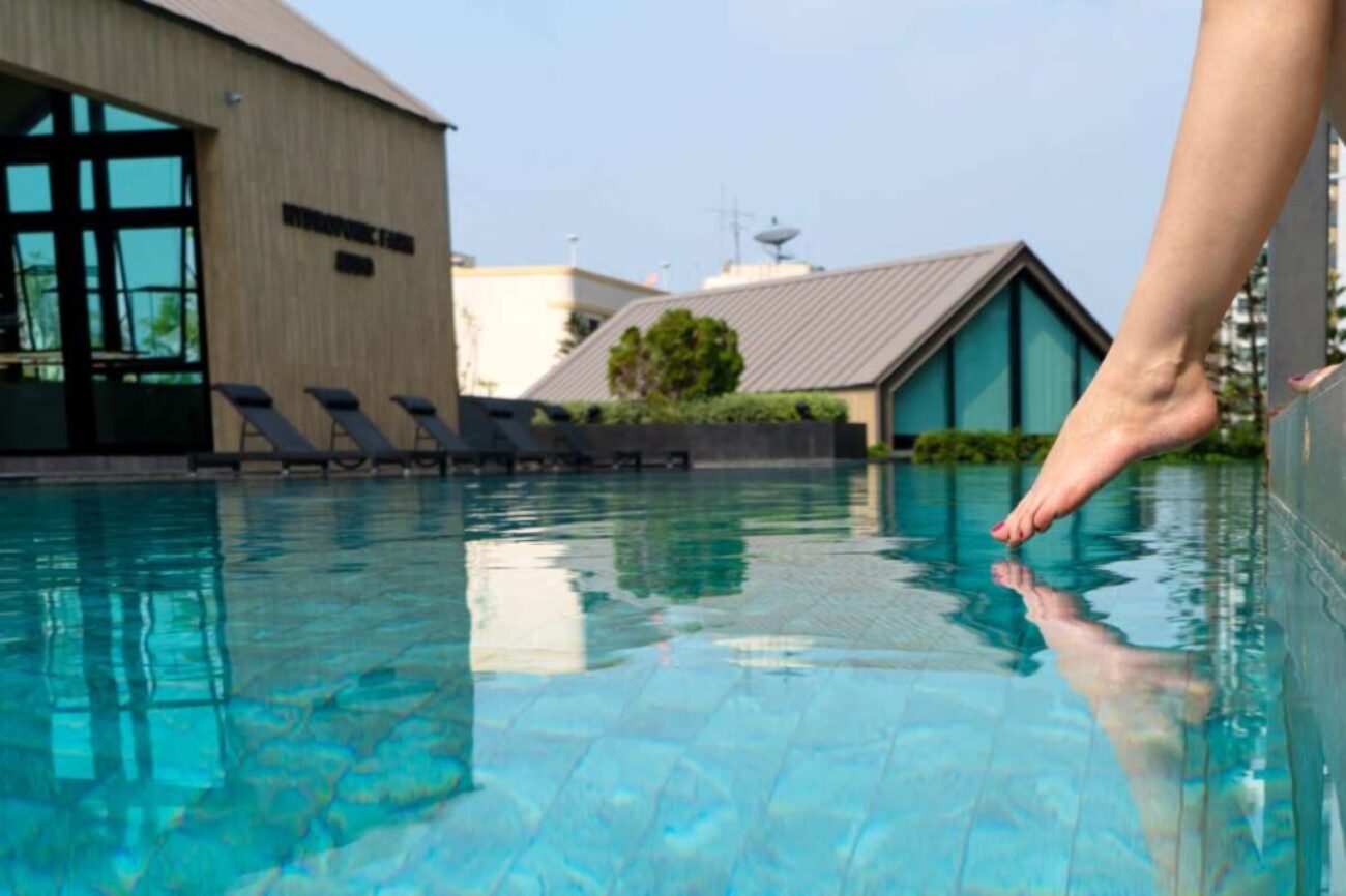 close-up-girl-s-leg-descends-into-pool-foot-touches-water-checks-water-temperature-before-swimming_0x800