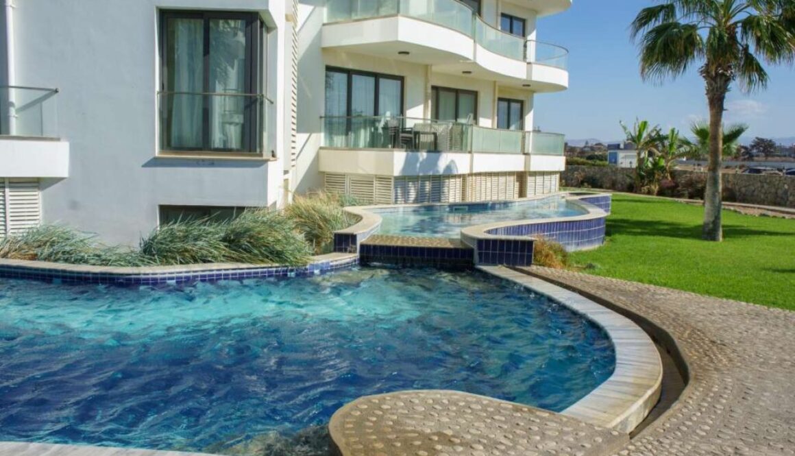 elegant-curved-poolside-view-modern-building-sunlit-outdoor-space-surrounded-by-greenery_0x800