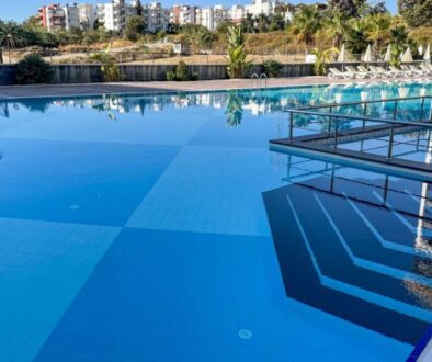 large-outdoor-swimming-pool-with-modern-glass-railings-serene-view-surrounding-greenery_0x800