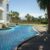 tranquil-oasis-with-swimming-pool-surrounded-by-palm-trees-sunny-day(1)_0x800